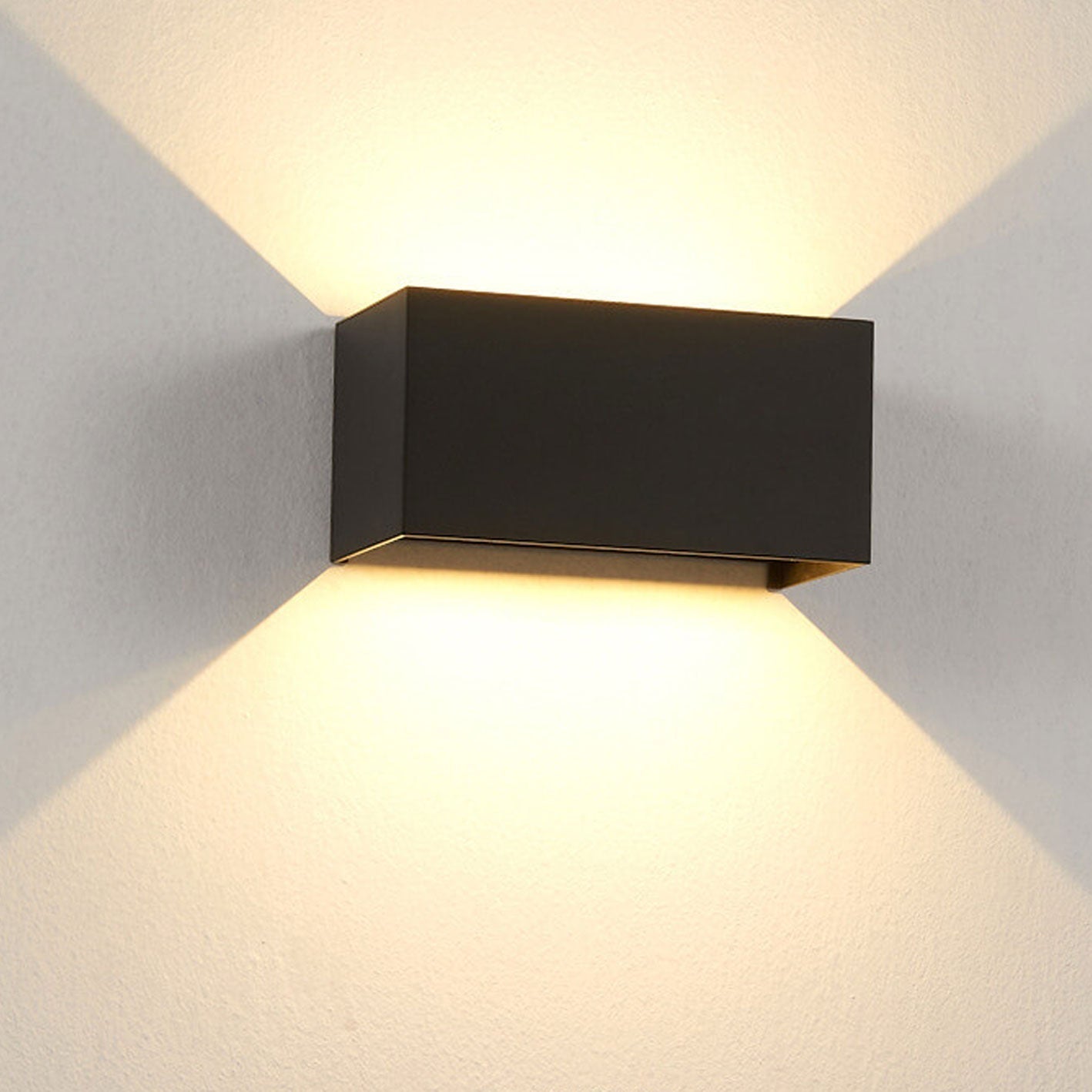Modern, waterproof, rectangular outdoor LED wall light with up and down lighting.