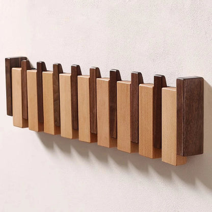 Wooden coat rack in piano design with foldable hooks | Karnz