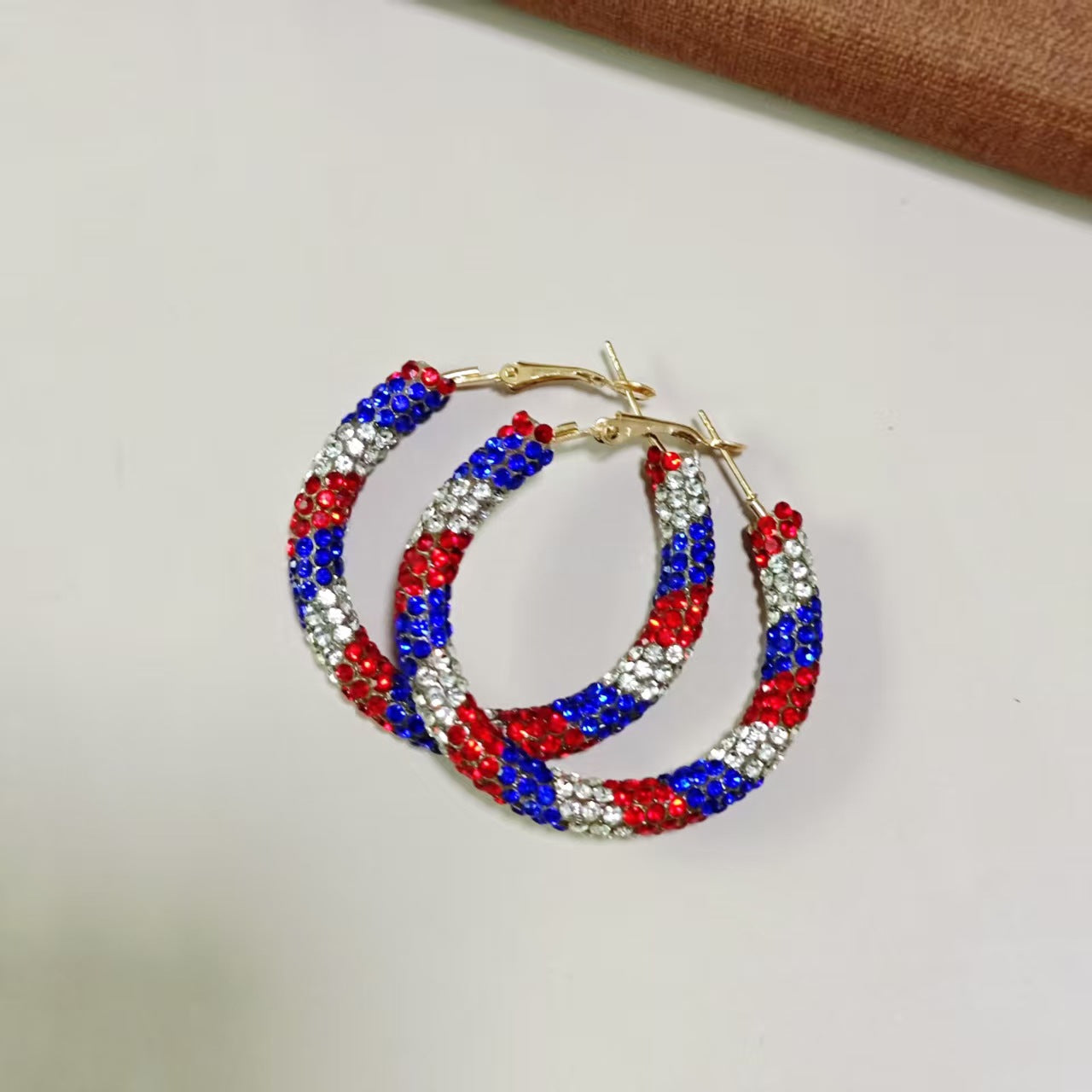 Women's handcrafted crystal pavé hoop earrings with curved tube element and clasp closure Bowlift
