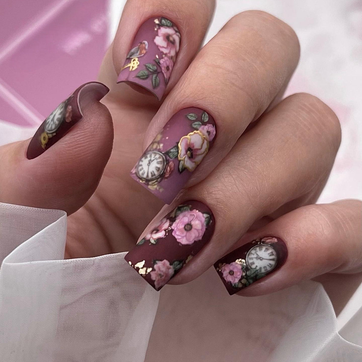 Nail art with floral design and intricate clock motifs Acalora