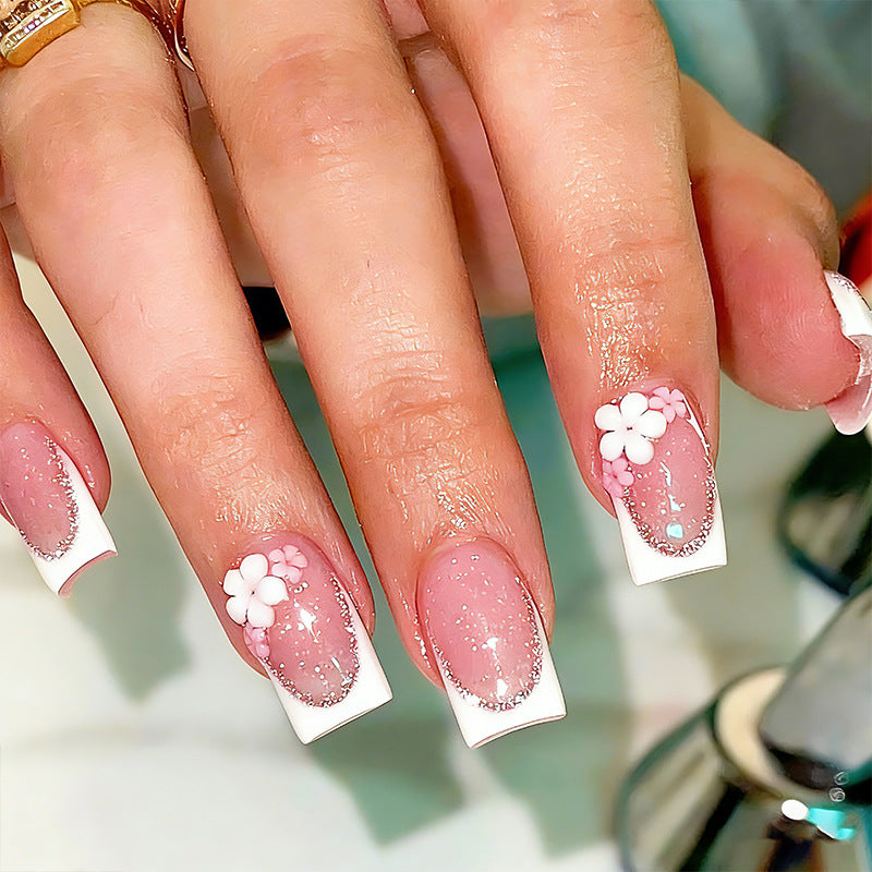 Acrylic nail set with elegant French tip and delicate floral decorations Acalora