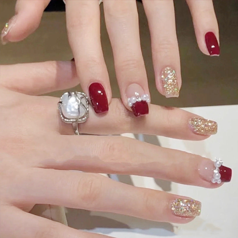 Glamorous artificial nails with glitter and pearl decorations Acalora