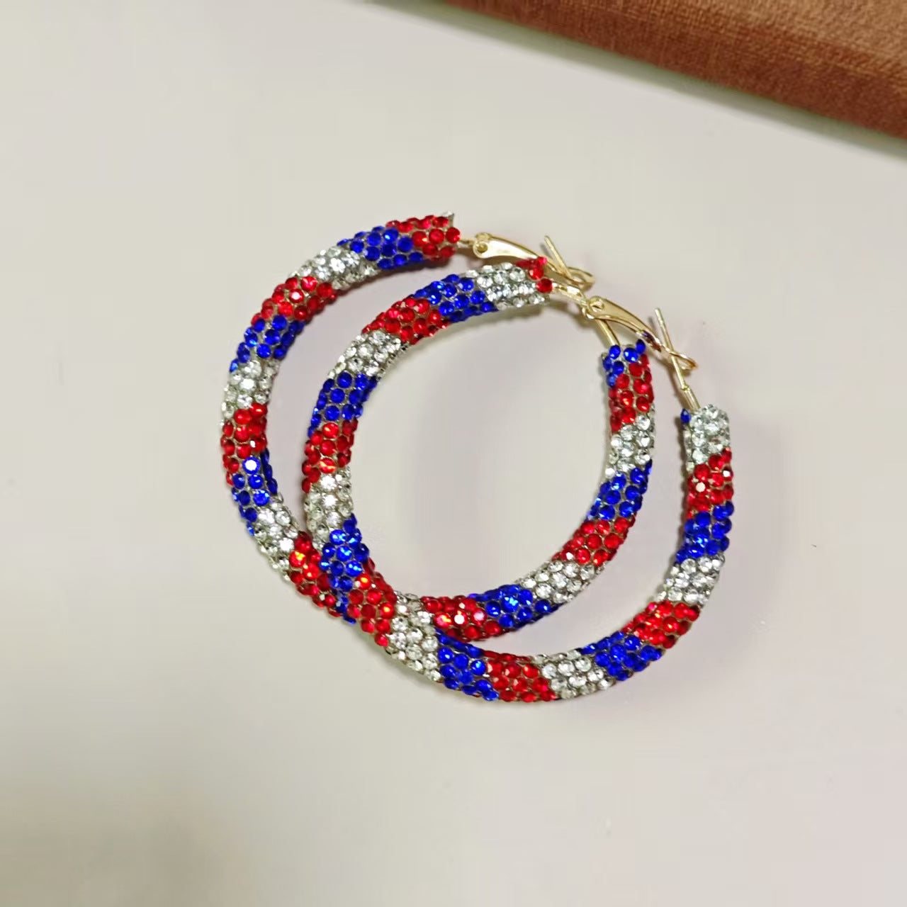 Women's handcrafted crystal pavé hoop earrings with curved tube element and clasp closure Bowlift