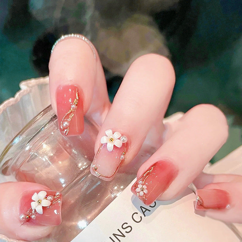Acrylic nail set with elegant floral decorations and glamorous pearl accents Acalora