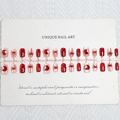 Artificial nail set with festive gift design and elegant glitter accents Acalora