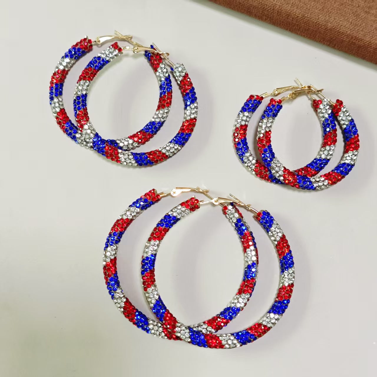 Women's handcrafted crystal pavé hoop earrings with curved tube element and clasp closure Bowlift