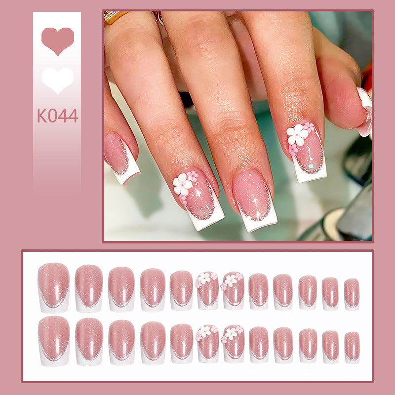 Acrylic nail set with elegant French tip and delicate floral decorations Acalora
