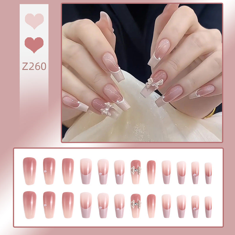 Artificial nail set with elegant ombre design and delicate bow embellishments Acalora