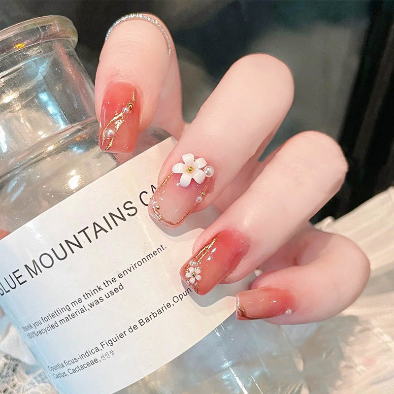 Acrylic nail set with elegant floral decorations and glamorous pearl accents Acalora