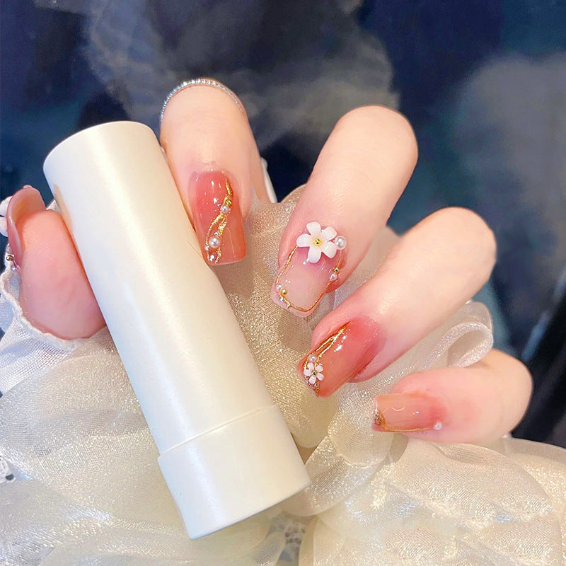Acrylic nail set with elegant floral decorations and glamorous pearl accents Acalora