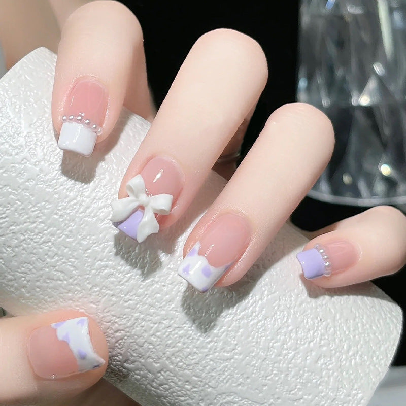 Nail art set with elegant wave patterns and delicate pearl accents Acalora