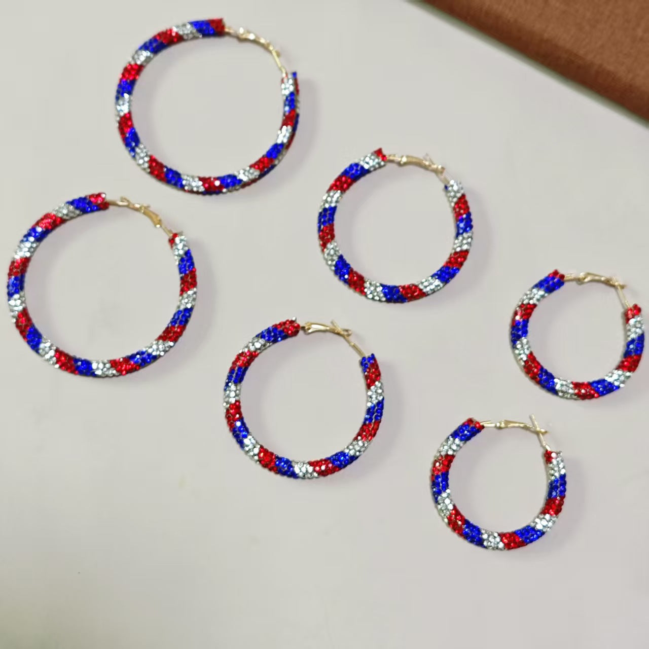 Women's handcrafted crystal pavé hoop earrings with curved tube element and clasp closure Bowlift