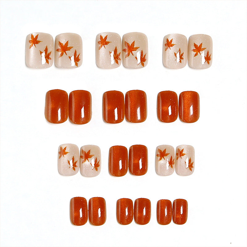 Artificial nails with glamorous ombre design and autumn leaf applications Acalora