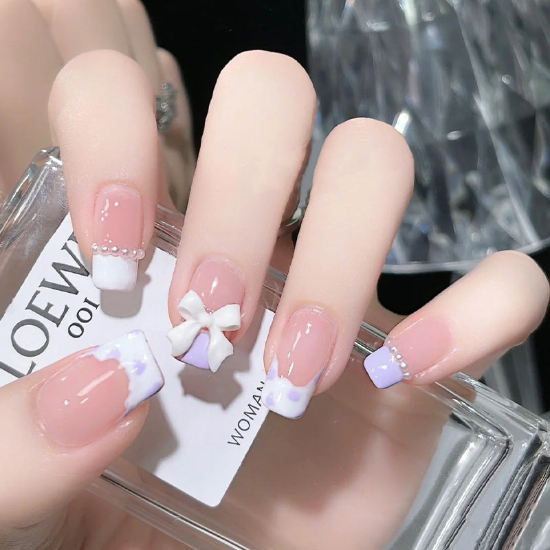 Nail art set with elegant wave patterns and delicate pearl accents Acalora