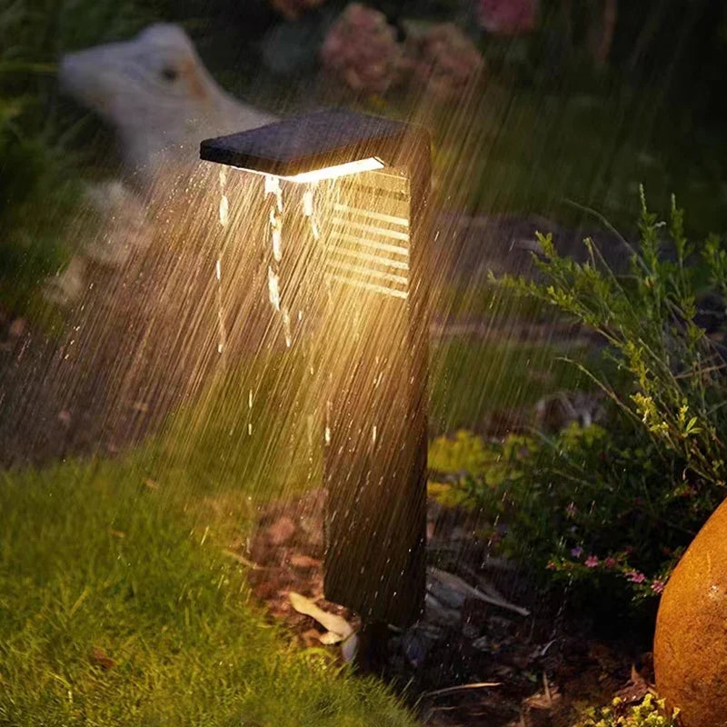 Spritzwassergeschützte Solarleuchte mit Lichtstrahl auf feuchtem Rasen